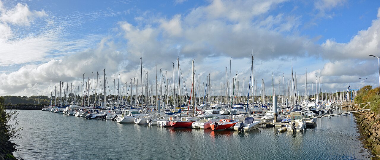 Voiliers et bateaux à moteur amarrés aux pontons de Port-la-Forêt sous un ciel nuageux